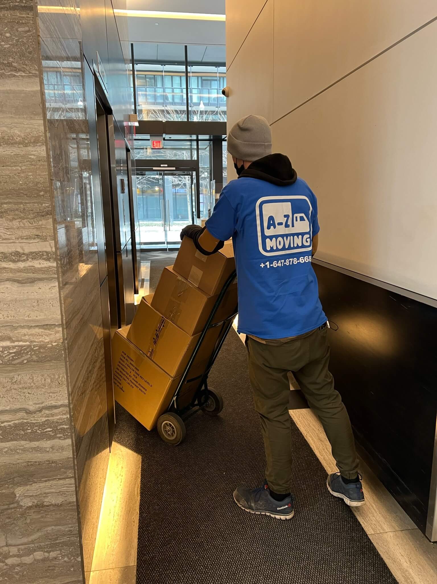 young-delivery-man-using-touchpad-while-reading-label-package 1